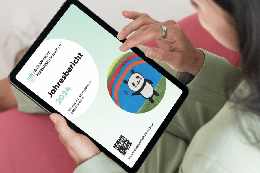 Eine Frau liest den Jahresbericht 2024 auf einem Tablet