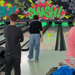 Eine Frau wirft eine Bowlingkugel