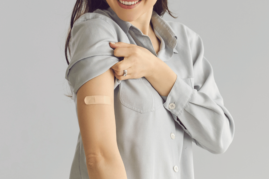 Frau mit Pflaster auf dem Oberarm