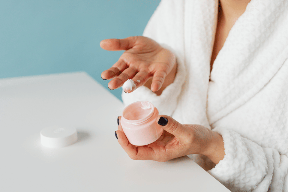 Eine Frau hält einen Cremetigel in der Hand