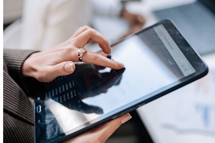 Eine Hand tippt auf einem Tablet.