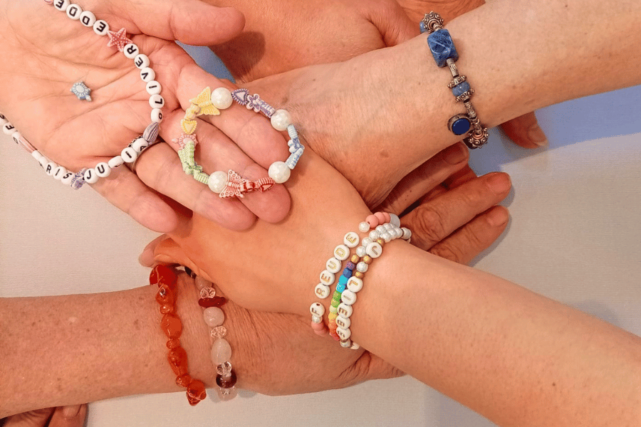 Vier Hände halten selbstgemachte Armbänder