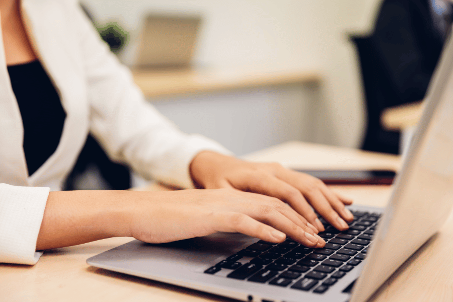 Eine Frau tippt auf einem Laptop